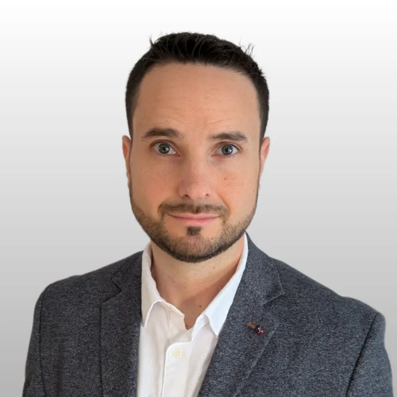 Portrait of Ibán Ríos in a grey blazer and white shirt